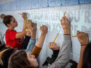 Students using a projector to start a mural