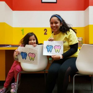Volunteer with child showing coloring pages