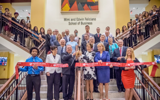 Dr. Cole and the Felicianos surrounded by students as they cut ribbon. 