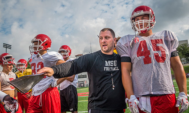 Coach Mike Palazzo instructing one of his football players.