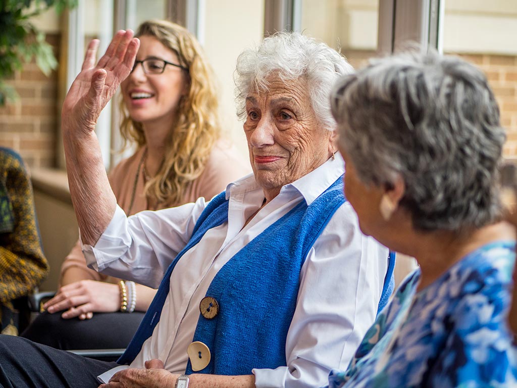 Lauren Corrente ’12 laughing and having discussion with Cedar Crest residents.