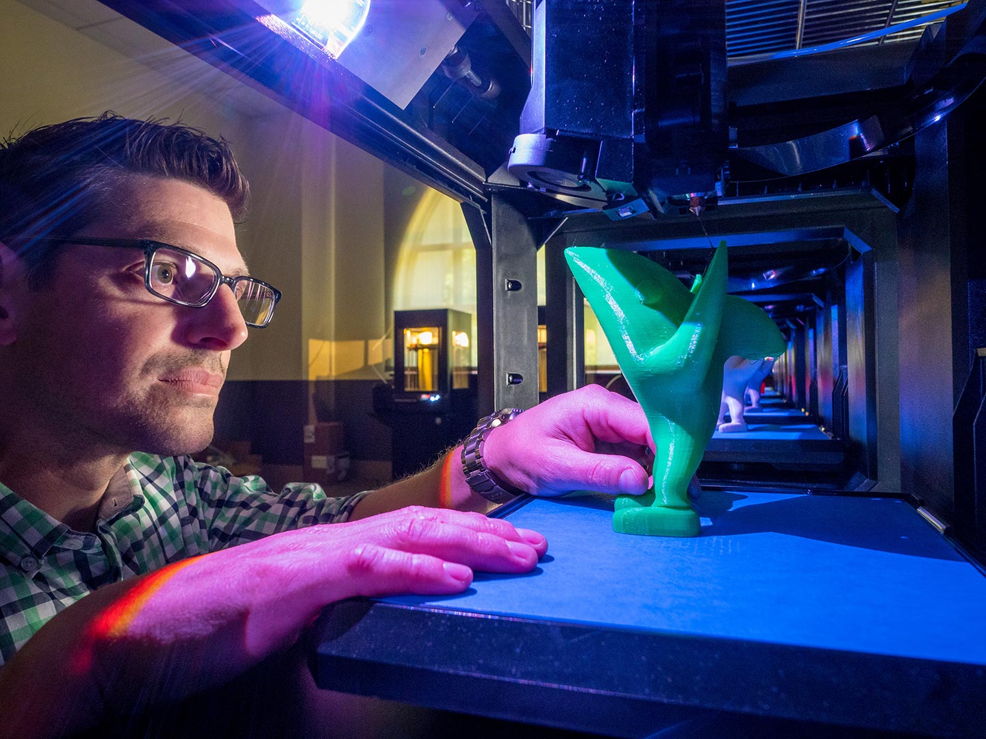 Jason Frasca inspects a printed object.