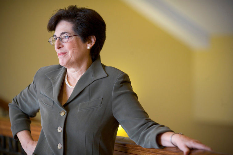 President Susan A. Cole smiling and leaning against railing.