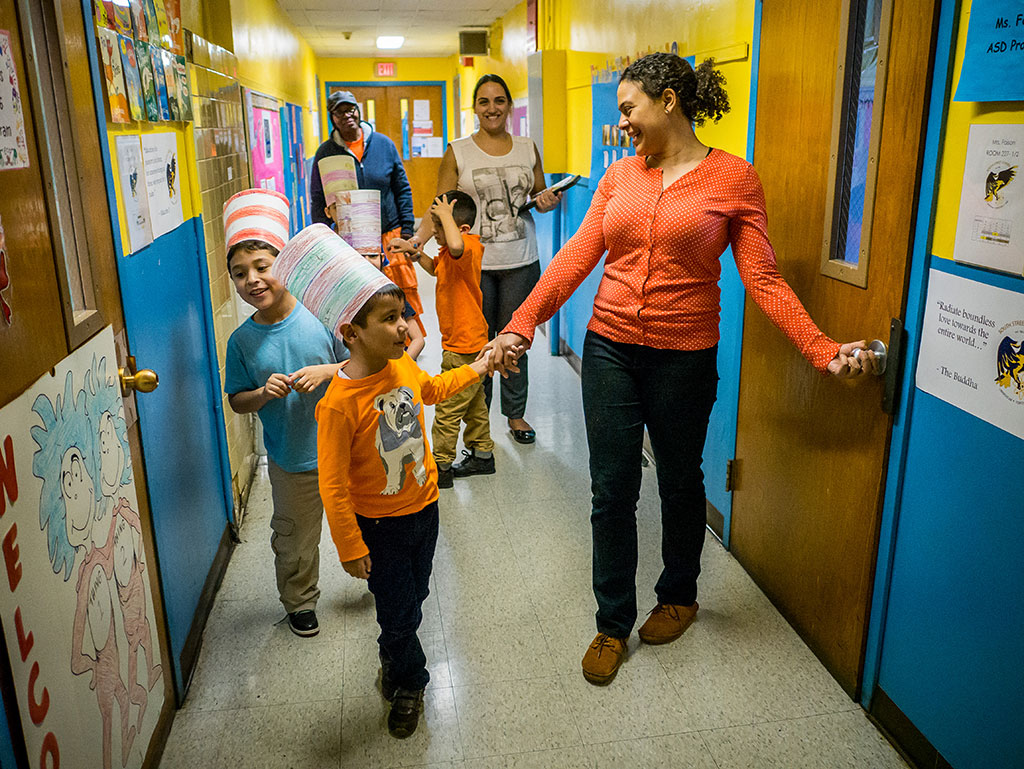 Amanda Faison holding child's hand and walking with other students and teachers.