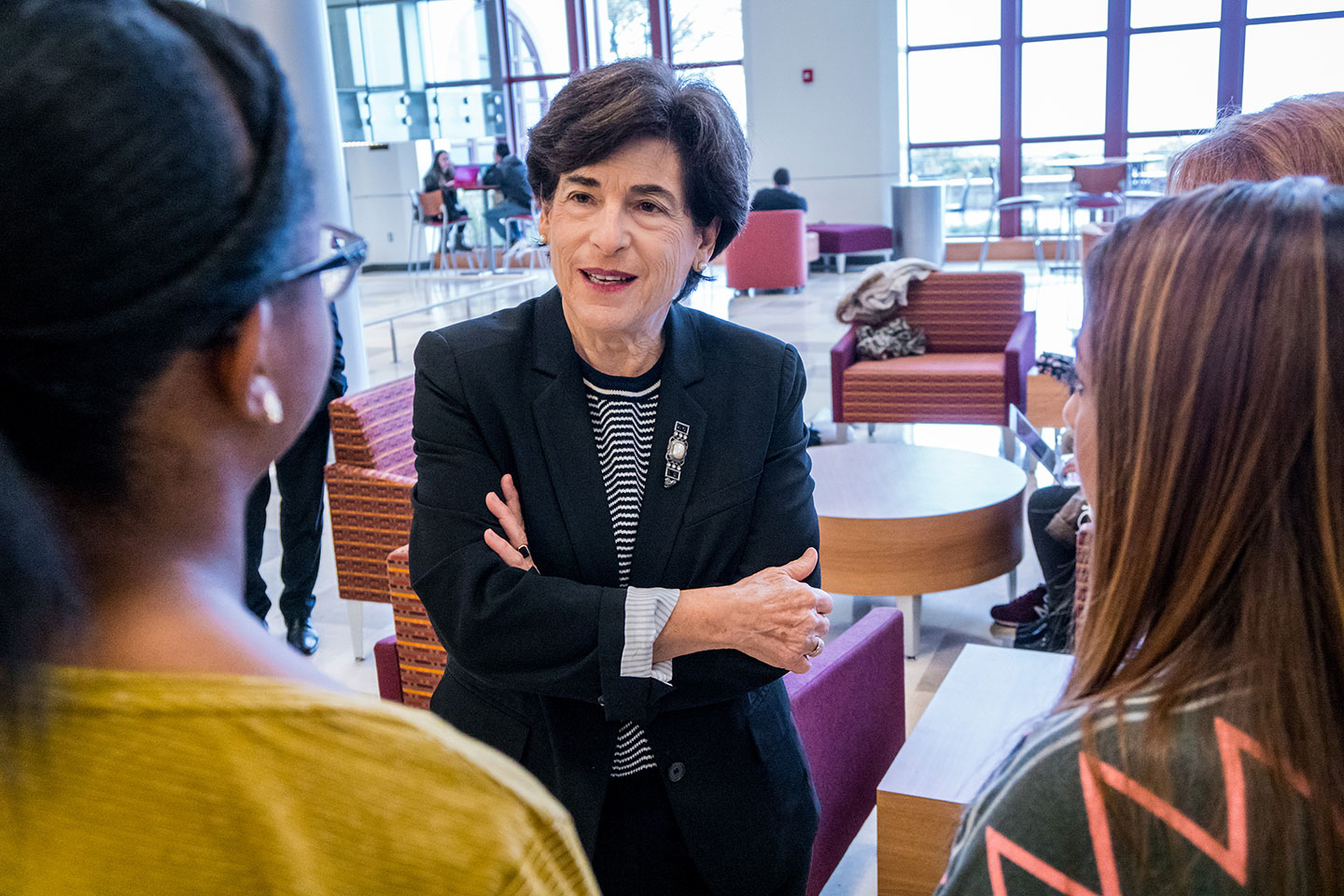 President Susan A. Cole speaking with a couple of female students.