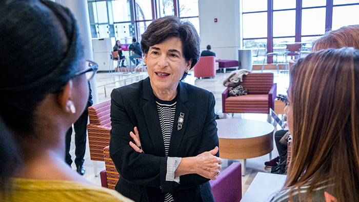 Photo of Susan A. Cole speaking with students.