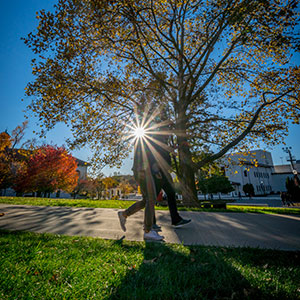 Students walking in front of the sun.