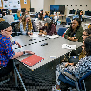 Students sitting around table helping in human rights workshop.