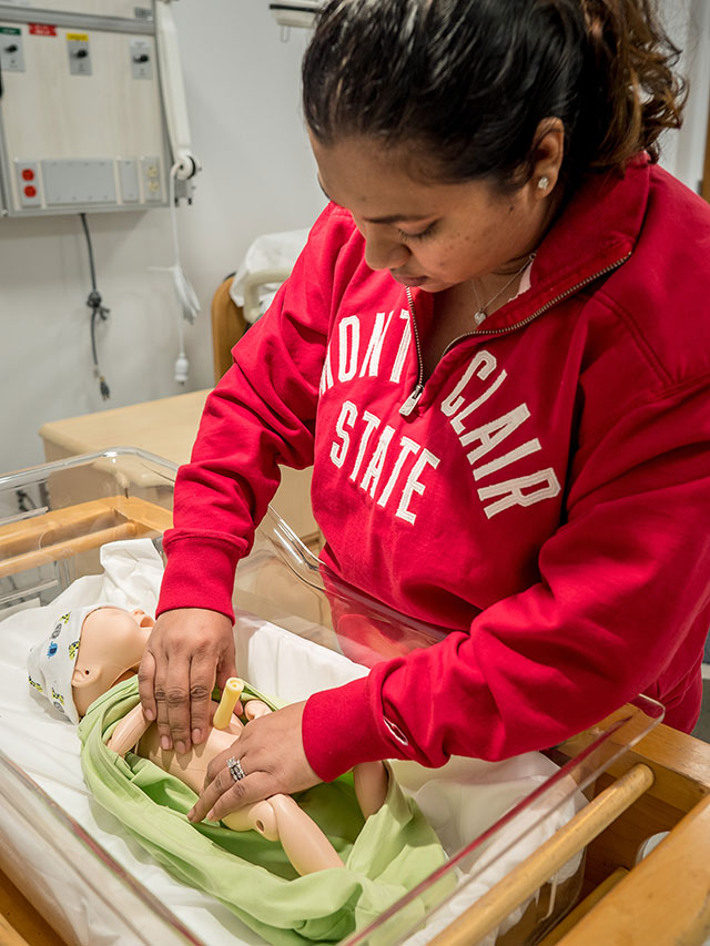 Student Sandy Hussain demonstrates how to care for an infant.
