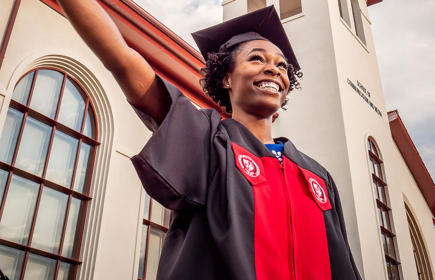Female MSU graduate waving EOF flag