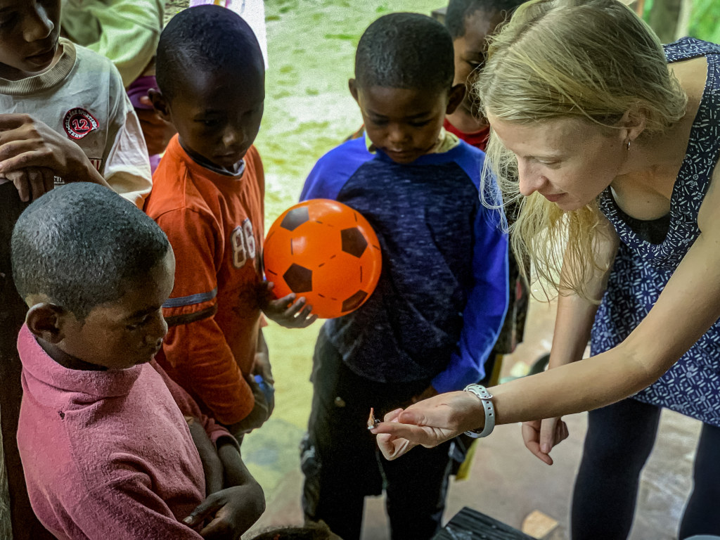 8. Borgerson shows some Malagasy children a sakondry insect.