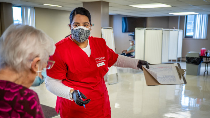 Aisha Shabbir, a sophomore BSN student, directs a resident to her inoculation. “I was just taking names and they thanked me over and over,” says Shabbir. “We started talking and I told them about my life and they told me about theirs.”