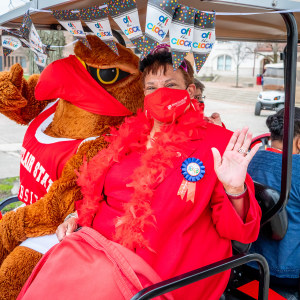 Karen L. Pennington and Rocky the Red Hawk wave at her retirement parade.