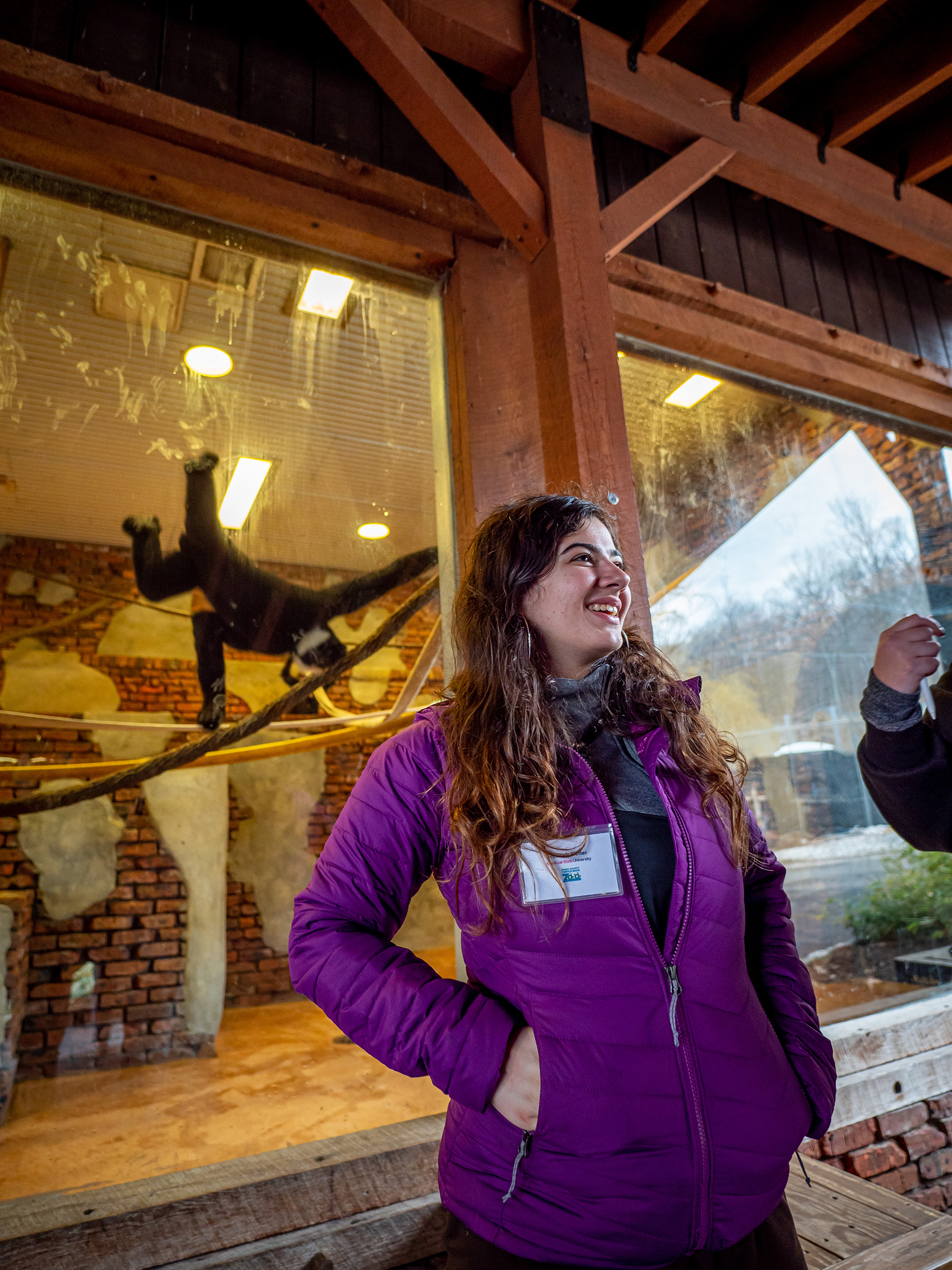 Hannah Kutler smiling in front of gibbon habitat
