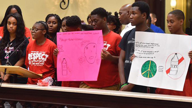 students from P-CASA holding signs advocating for liquor sale restrictions