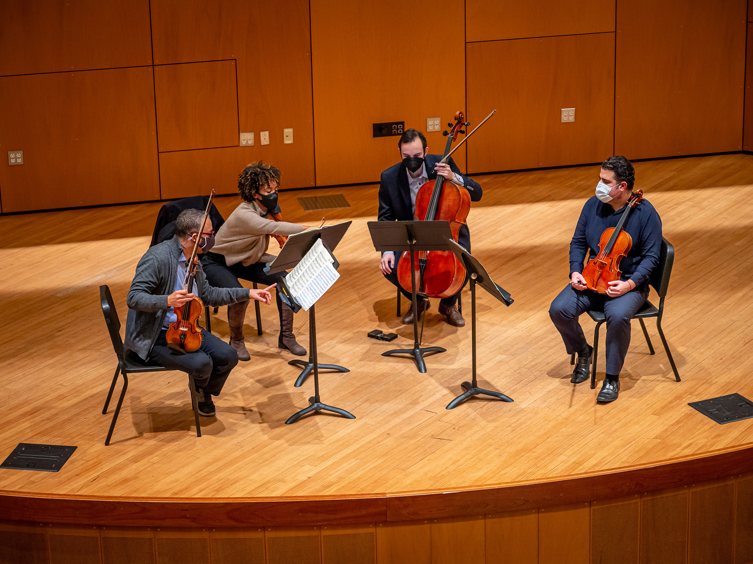 Members of the Harlem Quartet rehearsing on stage