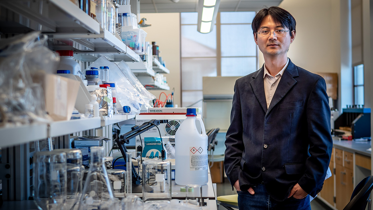 Yang Deng standing in a research lab