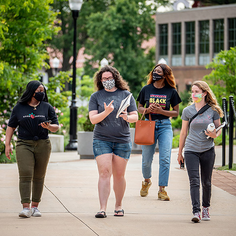 four students walking on campus