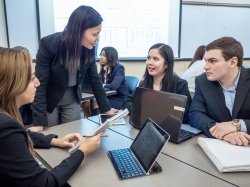 Photo of a teacher talking to a group of students.