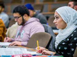 Photo of student in class taking notes.