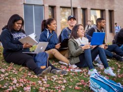 Group of students sitting outside and smiling