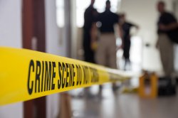 Photo of crime scene tape and forensic team.