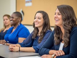 Students from the Graduate School laughing in classroom.
