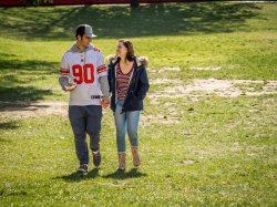 Photo of a man and a woman walking across a field and holding hands