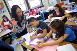 Photo of teacher with students in a classroom.