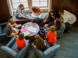 Group of students studying together around table.