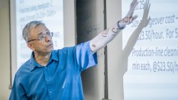Photo of professor gesturing at projected slides.