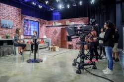 two students at high table on set in front of cameras