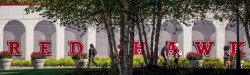 Students walking in front of Red Hawk mural on student center annex