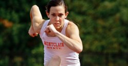 closeup of runner jumping over hurdle toward the camera