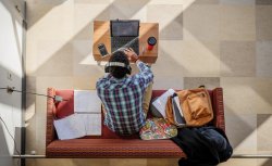 overhead view of student using laptop in lounge