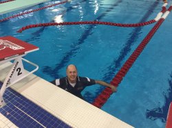 Photo of swim coach McLaughlin in the pool, fully dressed.