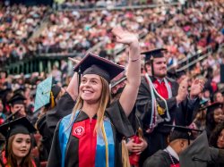 Graduate waving to her family