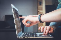 stock photo of fingers pointing at laptop screen