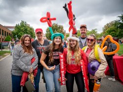 Homecoming attendees pose with balloon hats and flowers