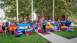 Group of students holding flags at base of flag pole