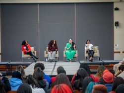 4 college students speaking at front of room.