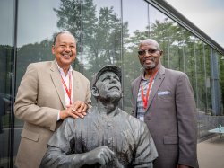 Attendees pose next to statue