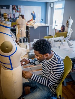 Fashion Student Applying Designs to Mannequin