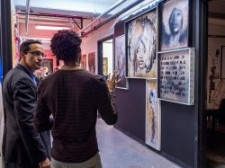 MFA Student and Faculty discussing artwork on display