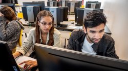 Two students looking at a computer monitor
