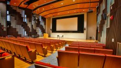 Presentation Hall with large stage and screen and seating at the School of Communication and Media