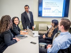 Students gathered at table watching presentation