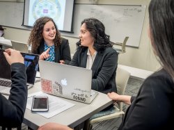 faculty member sitting with students