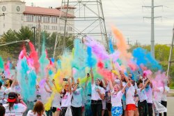 Group of students throwing up different colored powder at the Red Hawk Run
