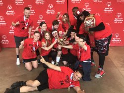 Twelve people from united sports holding a trophy